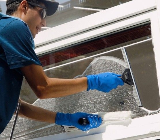 Vcare technician cleaning a commercial storefront window